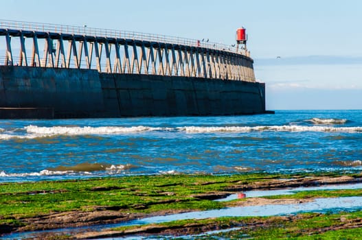 Scenic view of Whitby Pier in sunny autumn day.Whitby's attraction as a tourist destination is enhanced by its association with the world famous horror novel Dracula, written by Bram Stoker