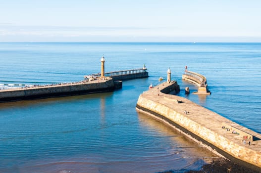 Scenic view of Whitby Pier in sunny autumn day.Whitby's attraction as a tourist destination is enhanced by its association with the world famous horror novel Dracula, written by Bram Stoker