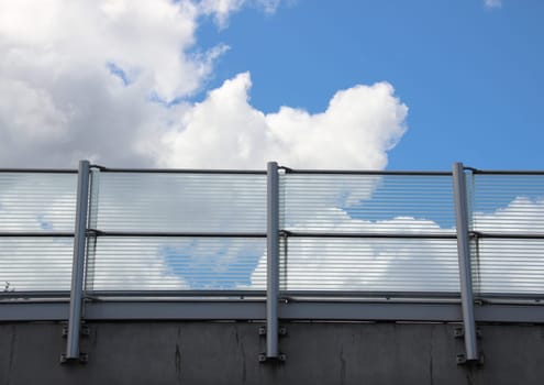Metal and glass railing with blue sky horizontal