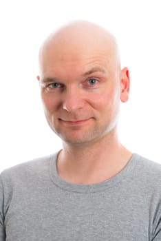 funny young man with bald head is smiling in to the camera