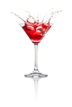 Red cocktail with ice cubes and splashes