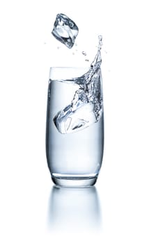 Water glass with ice cubes and splashes