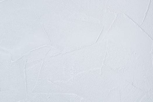 The texture of a white wallpaper designed to look like plaster.