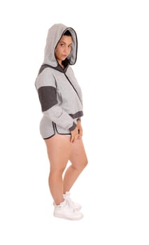 Full size picture of a pretty woman in a gray hoodie and shorts, standing.in profile isolated for white background..