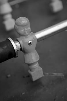 Figures of a table football game in close-up. The figures have a side parted hairstyle.
