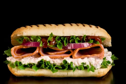 Ham and vegetable sandwich on a black background