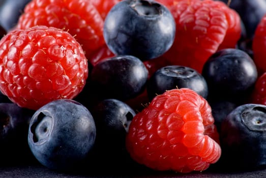 Closeup of fresh blueberries and raspberries mixed toghether