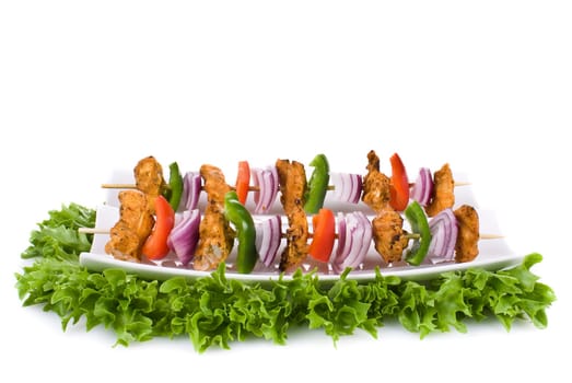 Skewers with chicken and vegetables on the plate - isolated