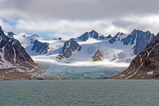 Tidal Glacier and Snowy Mountains in the High Arctic in the Svalbard Islands in Norway