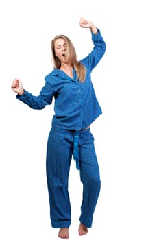A young yawning and stretching woman waking up in her pajamas in the morning