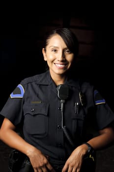 a smiling police officer posing for her portrait in the night.