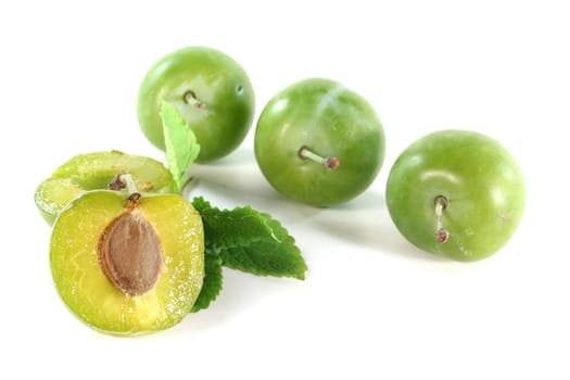 fresh green Mirabelle plums on a white background