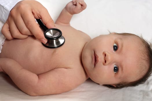 Photo of a doctor checking a baby's heartbeat with a stethoscope.
