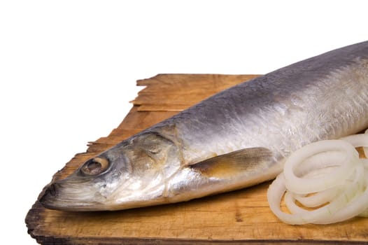 Herring with onion rings on old wooden board. Isolated on white background.