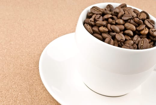 Close coffee cup filled with coffee beans