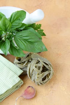 Mortar with pasta  and basil herbs