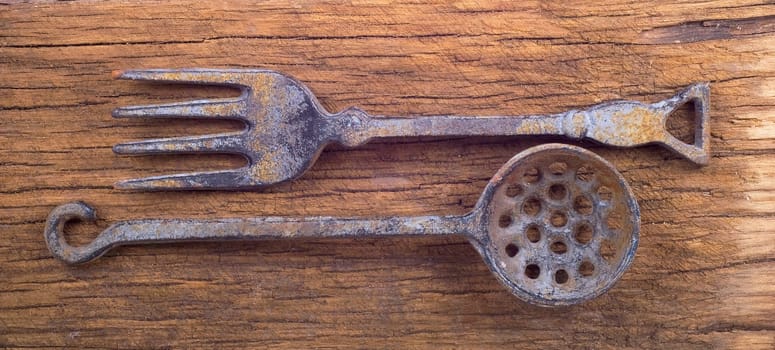 Ancient metal tableware on a wooden blackboard