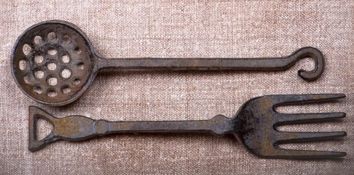 Ancient metal tableware lie on a canvas