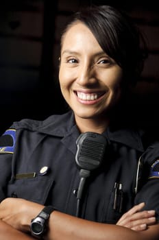 a female police officer smiling at night and posing for her portrait.