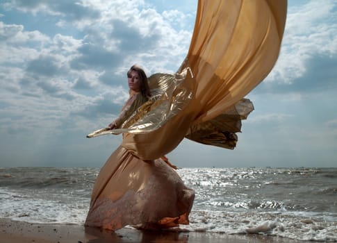 beautiful woman in exotic dress standing on the beach. Sea ​​of ​​Azov