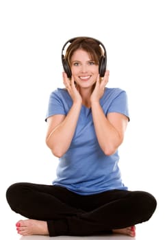 pretty casual brunette is listening to music on white background
