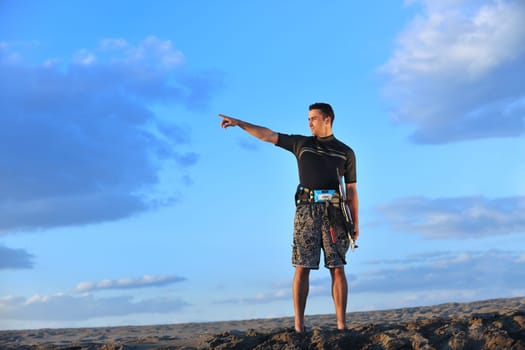 Portrait of a strong young  surf  man at beach on sunset in a contemplative mood with a surfboard