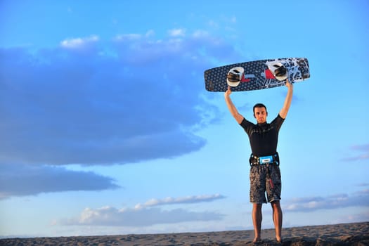 Portrait of a strong young  surf  man at beach on sunset in a contemplative mood with a surfboard