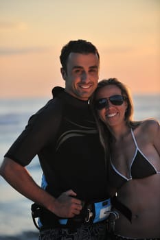 romantic couple in surf wear posing at beach on sunset at summer season