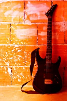 Electric guitar on old wall and stump with copyspace