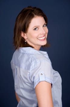 pretty casual brunette wearing blue top on dark background