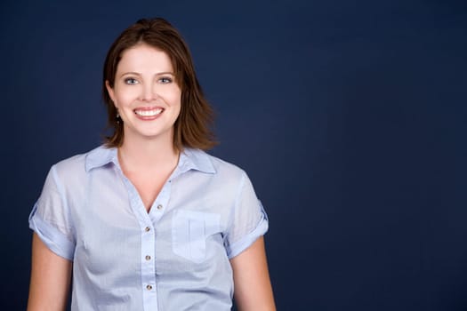 pretty casual brunette wearing blue top on dark background