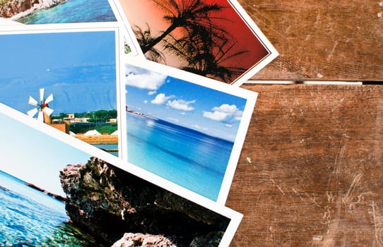 Pile of postcards - or photos - over an old wooden table