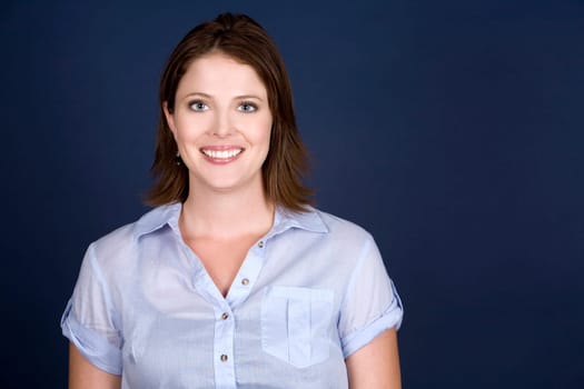 pretty casual brunette wearing blue top on dark background