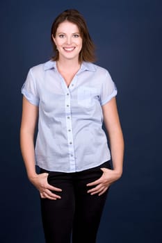 pretty casual brunette wearing blue top on dark background