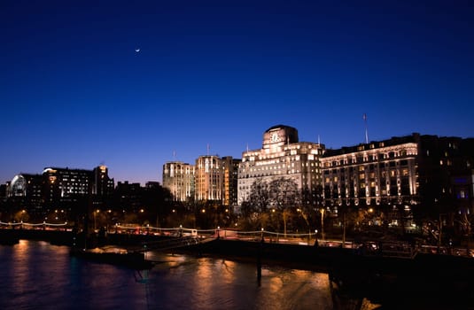 London Victoria Embankment Night View seen from Waterloo Bridge - Embankment Place, Adelphi Terrace and Shell Mex House from Left .
