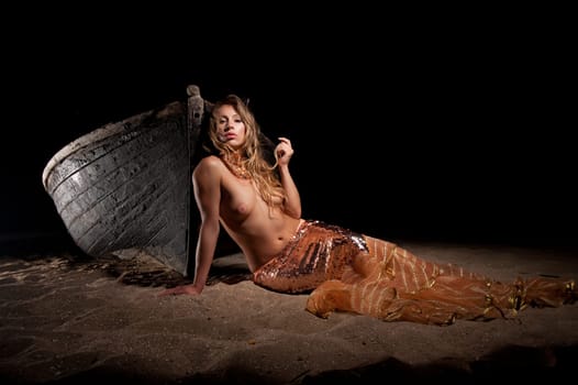 woman in exotic dress standing on a boat on the beach