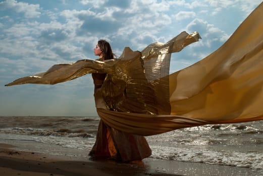 woman in long dress standing on the beach