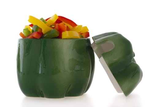 Ceramic green pepper shaped ornament filled with cut colofrul bell pepper slices.