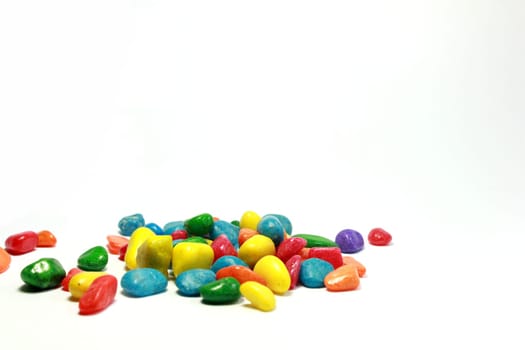 A number of brilliantly coloured pebbles against a white background .