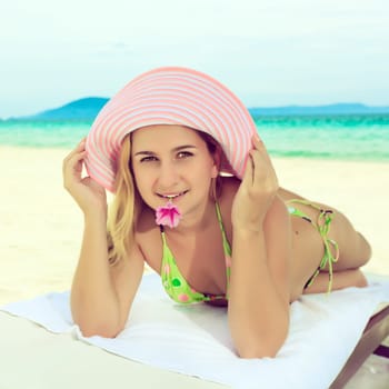Young woman sunbathing on the chair near the ocean