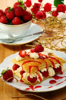 Milfeis with strawberries and berry sauce on a white plate.