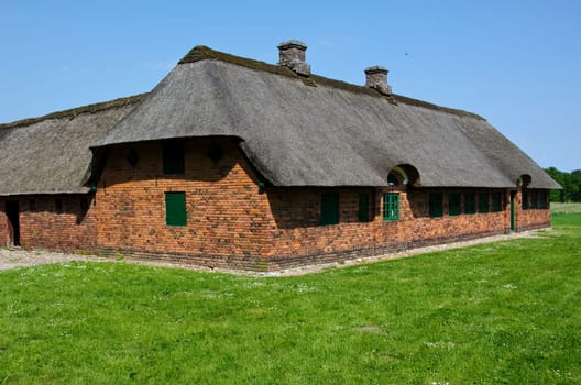 Medieval farm house build of bricks with thatched roof