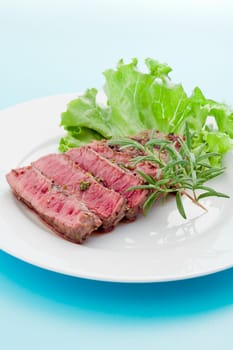 photo of delicious and pefect cooked beaf steak with rosemary and lettuce