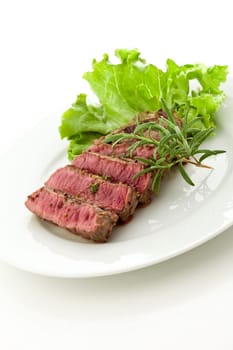 photo of delicious and pefect cooked beaf steak with rosemary and lettuce