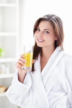 Beautiful girl in a bathrobe with a glass of juice