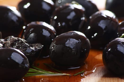 Black olives close up on a wooden table