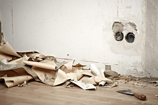 dirty room with wallpaper on the ground