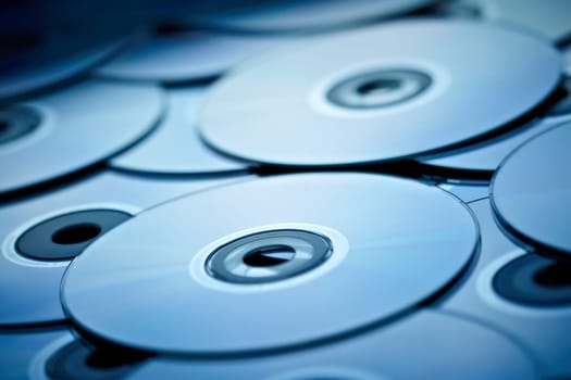 blue tinted close-up of a stack of cd-roms