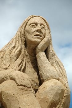 Sand sculpture of a sad woman.