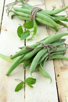 pods of green peas on a wooden table